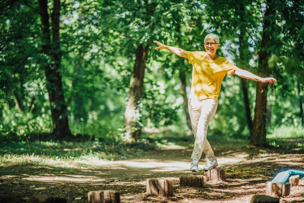 A woman doing balancing exercises outdoors.