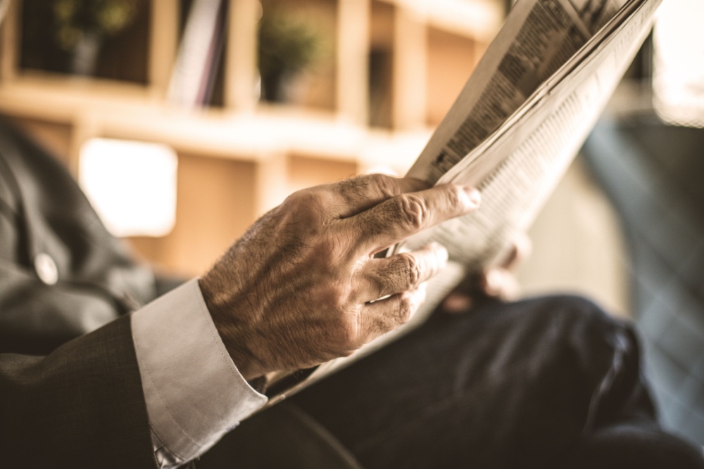 Senior businessman at his office reading a newspaper.